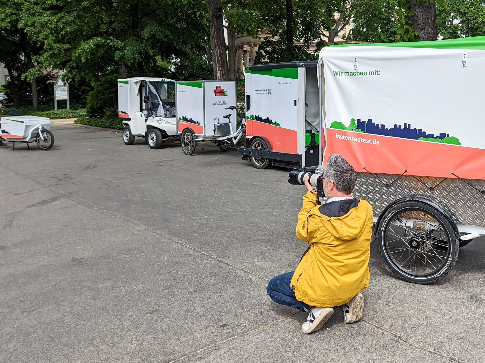 Ein Fotograf fotografiert mehrere Lastenräder auf der Straße