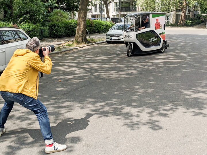 Ein Fotograf fotografiert ein Lastenrad auf der Straße