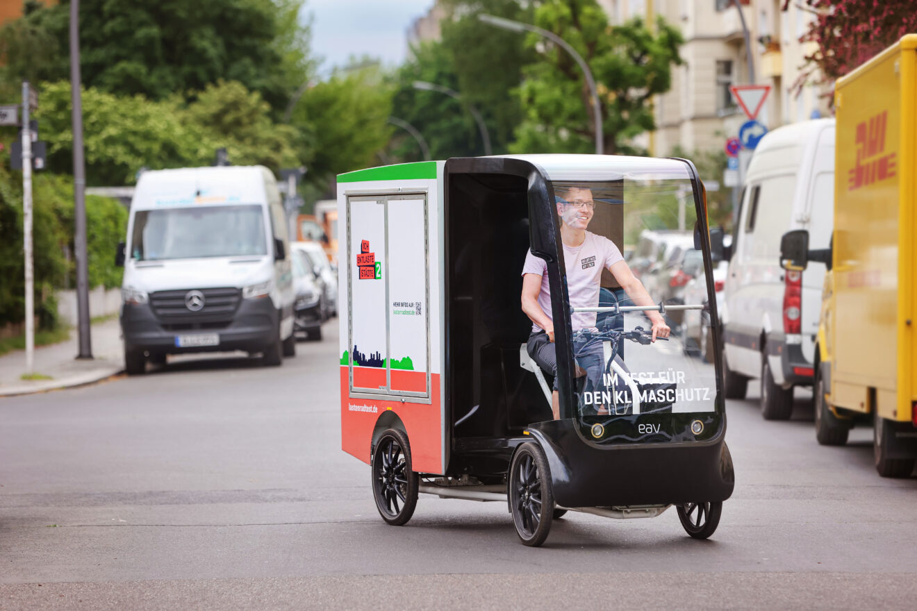 Ein junger Mann fährt mit dem Schwerlastenrad EAV 2Cubed durch die Stadt