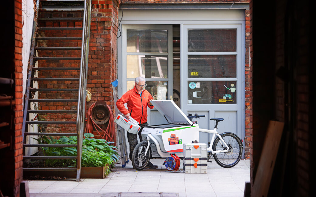 Ein Handwerker belädt die Transportbox des E-Lastenrades Larry vs Harry eBullitt mit Werkzeug-Containern