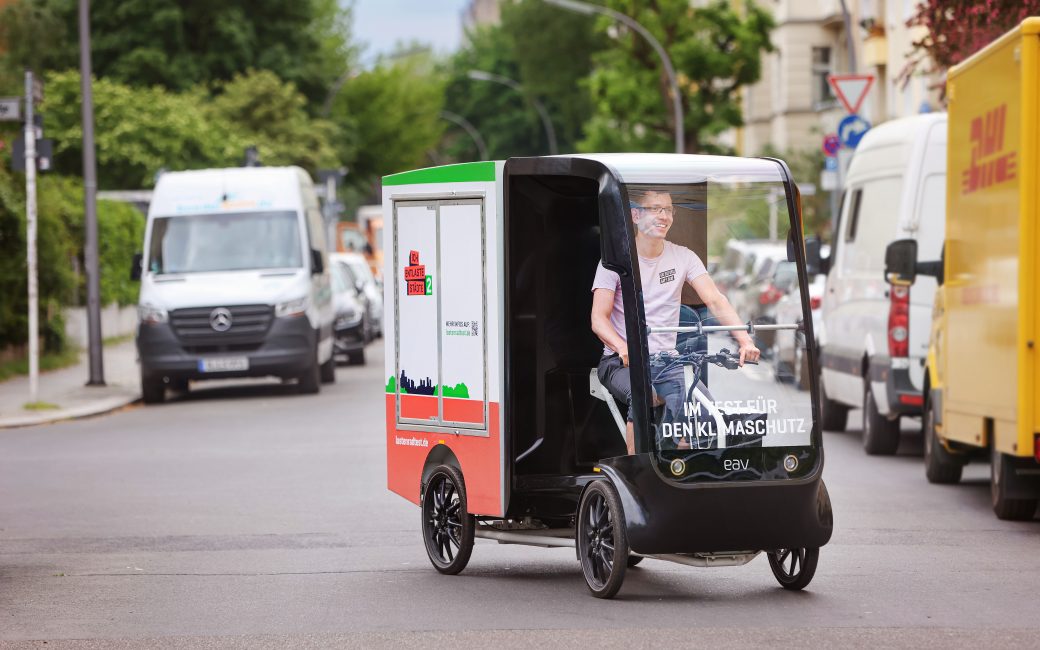 Ein junger Mann fährt mit dem Schwerlastenrad EAV 2Cubed durch die Stadt